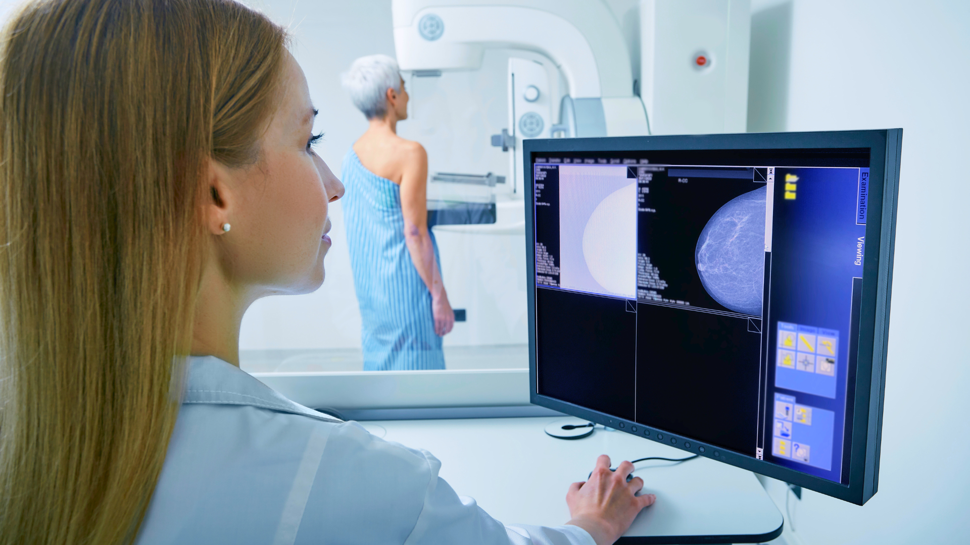 Médica realizando o exame de mamografia em uma paciente.
